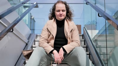 Panda Eriksson sitter i en trappa fotograferad nerifrån.