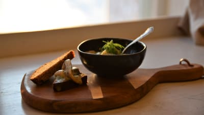 Ett brödskiva med senapsill på ett skärbräd och en skål med senapsill brevid på ett bord