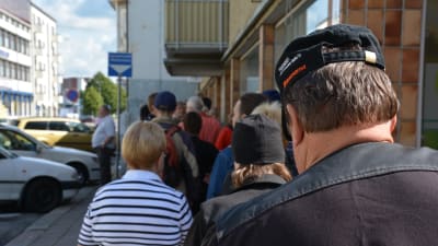 Människor väntar på mat i en lång brödkö i Åbo.