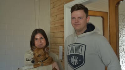Ett ungt par med hund i famnen