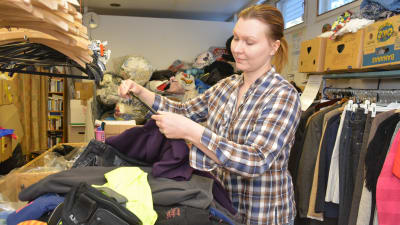 Laura Pihlaja sorterar återvunna plagg på Emmaus-Westervik.
