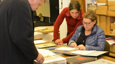 Ortsborna Rauno Nikkanen, Riikka Niemistö och Arja Aminoff studerar arkiv.