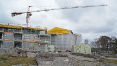 Arbetsplats där en lyftkran syns ovanför bostäderna som byggs på Fabriksudden i Hangö.