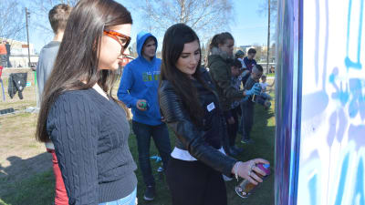 Hannah Hasselberg målar graffiti på Raseborg offspring 2016. Jennifer Augutsson ser på.