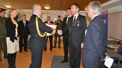 Thorbjörn Sirén och Bernt Ehrnrooth från Nylands brigads gille överräcker det nya gymet till brigadkommendör Kjell Törner.