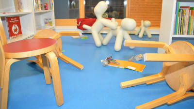 Omkullfallna stolar och skräp på golvet i Ingås bibliotek.
