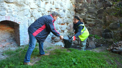 Museichef Dan Lindholm hjälper arkeolog Tarja Knuutinen vid utgrävningarna på Raseborgs slott.