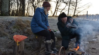 Elin Skagersten-Ström och Anders Samuelsson grillar smörgås på öppen eld på stranden vid Strömsö.