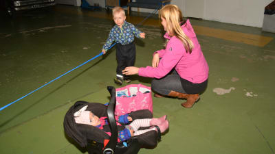 Stephanie Grönroos hjälper sonen Hampus med kläderna. Dottern Hilma i bilstol.