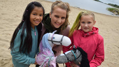 Lee och två flickor med käpphästar