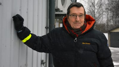 Lars-Olof Lindqvist utomhus och lutar sig mot en vägg.