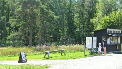 Turister läser skylt vid Raseborgs slottsruiner.