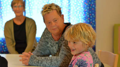 Raul Carusi, 6 år, sitter vid ett bord tillsammans med barnträdgårdslärarna Valborg Vilhjalmsdottir och Heidi Kihlstedt på Solbacka daghem i Karis,