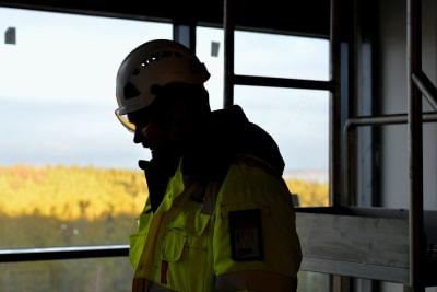 Siluetten av processkötare Ronnie Gustafsson inne på nyaste fabriken på Fermions fabriksområde i Hangö. I bakgrunden utsikt över skog. 