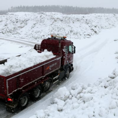Kuorma-auto kuljettaa lunta.