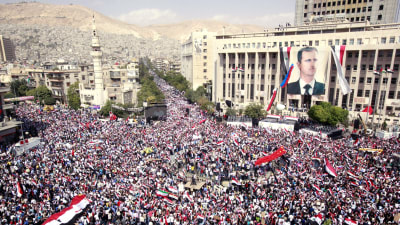 Syrier visar sitt stöd för regeringen och presidenten Bashar al-Assad i Damaskus i oktober 2011.