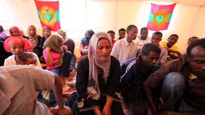 Flyktingar från Oromo i Libyen sörjer drunknade flyktingar. I bakgrunden syns rebellflaggan för Oromos Befrielsefront