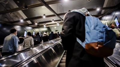 Människor står i en rulltrappa