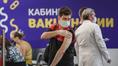 En ung man har fått coronavaccin i shoppingcenter i Moskva. 