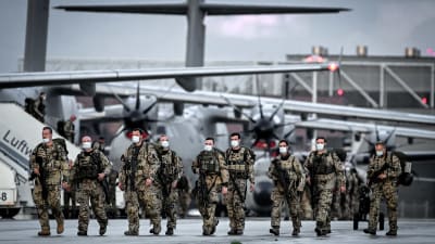 Tyska soldater går framför ett flygplan på flygfältet i Wunstorf. De ahr återvänt från evakueringsinsatsen i Afghanistan.