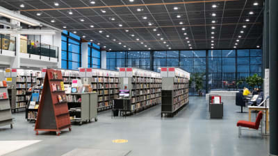 Bibliotekshyllor och till höger ett öppet utrymme med en scen.