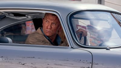 Närbild på James Bond (Daniel Craig) som kör bil och ser bekymrad ut.
