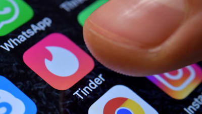 En mobilskärm där bland annat Tinders applikations logo syns.
