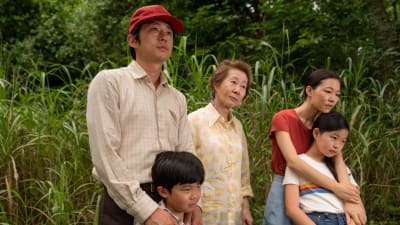 Jacob (Steven Yeun), sonen David (Alan S. Kim), svärmor Soon-ya (Yuh-Jung Youn), frun Monica (Yeri Han) och dottern Anne (Noel Cho) står tillsammans i ett grönt landskap.