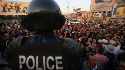 En irakisk polis övervakar demonstrationen i Bagdhad