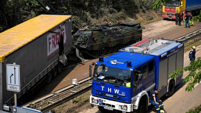 En blå lastbil och en pansarvagn bredvid en skadad lastbilskärra med texten Freja på sidan.