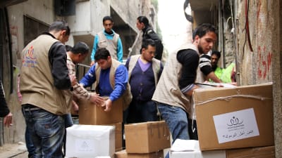 UNRWA-medarbetare delade ut nödhjälp till palestinier i flyktinglägret al-Yarmouk i utkanterna av Damaskus i mars 2015.