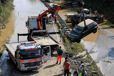 En bil bärgas ur vattnet i Erftstadt i Tyskland. 