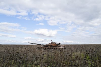 En förstörd rysk stridsvagn på ett fält.