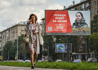 Siviili kävelee ohi Venäjän asevoimien mainoksen.