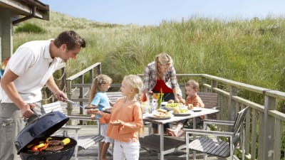 barnfamilj grillar utomhus