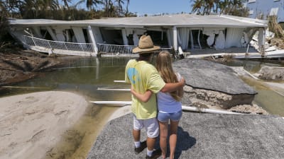 Mike Gilbert kramar om sin dotter Brooke då de ser på sitt förstörda hus i Islamorada i Florida Keys