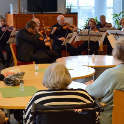 Vanhukset kuuntelevat kaupunginorkesterin konserttia.