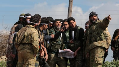 Proturkiska rebeller, män i militära kläder står och diskuterar i en halvcirkel. 