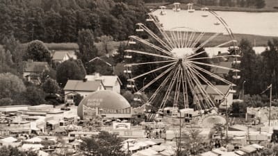 Svartvit bild av Ekenäs höstmarknad med tivoli och pariserhjul.