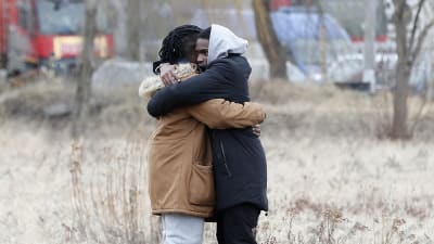 Kaksi pakolaista halaa.