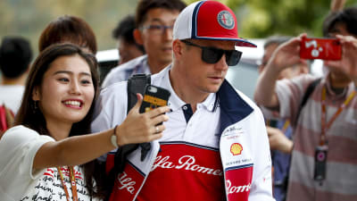 En kvinna tar en selfie med Kimi Räikkönen.