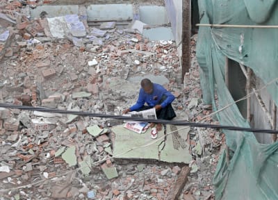 En man läser en tidning på en byggarbetsplats i Rangoon, Myanmar den 4 november 2022. 