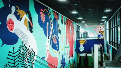 Värikäs seinämaalaus Myyrmäen juna-aseman sisäseinässä.