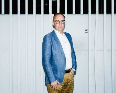 Jarkko Eloranta står framför en port av metall. 