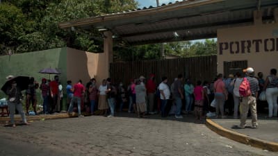 Människor utanför en sjukhusport i Managua.