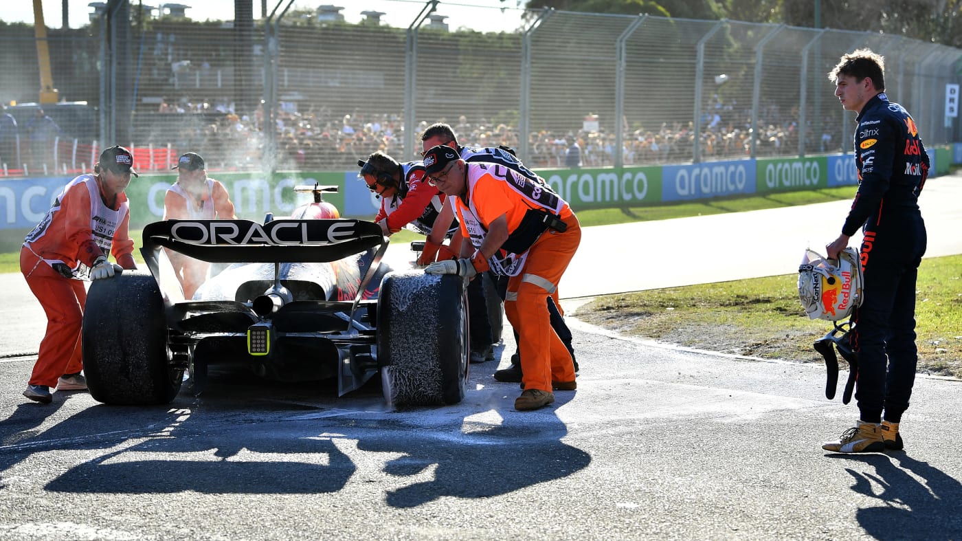 Max Verstappen guarda la sua macchina abbandonata che è stata spenta.