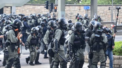 Bild på kravallpolis iklädda uniformer och hjälmar.