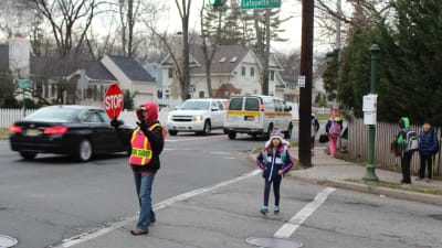 Jennifer Duteil stoppar trafiken medan ett barn går över gatan i Chatham, New Jersey.