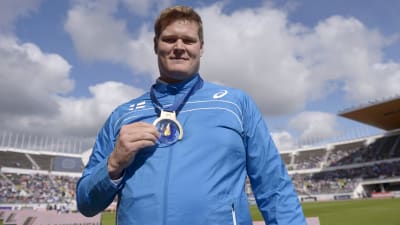 Olli-Pekka Karjalainen visar upp sitt EM-guld på Olympiastadion i Helsingfors.