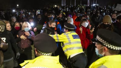 En polis ser ut att knuffa undan en demonstrant. 